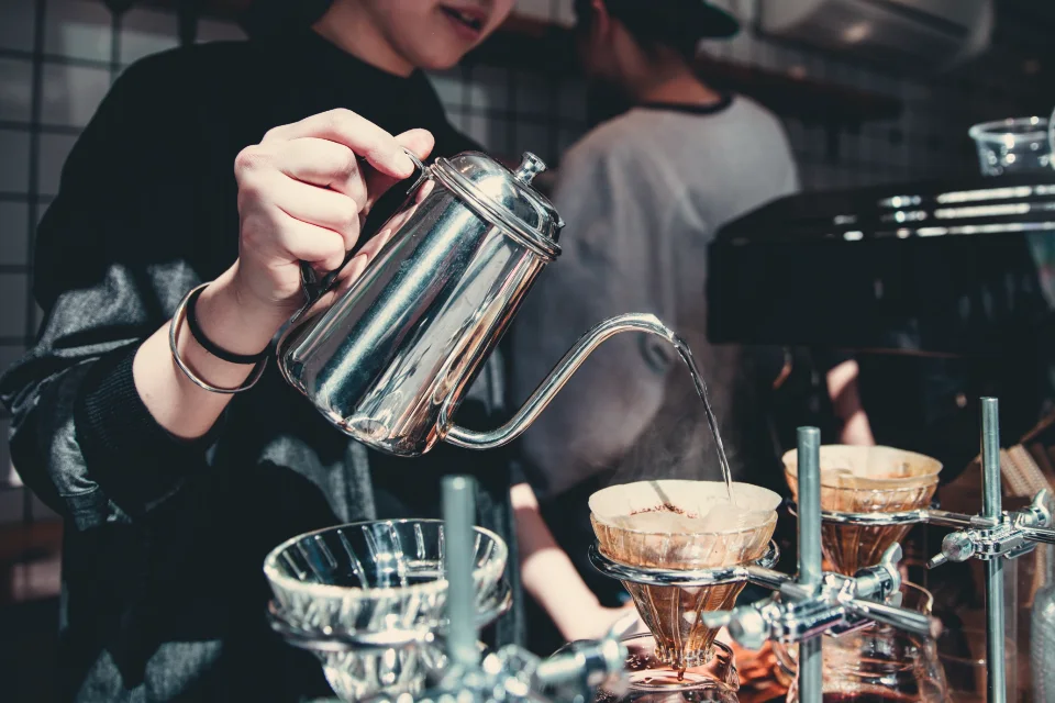 A barista preparing coffee behind the bar