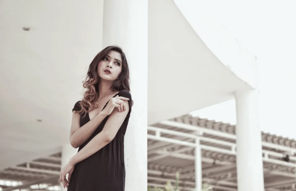 Model in a dark dress against white architecture